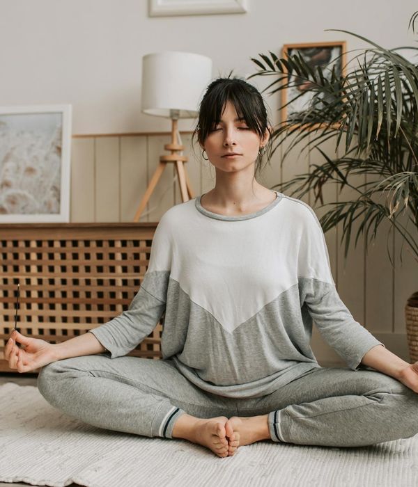 Woman in a calm, balanced yoga pose, surrounded by soft light.